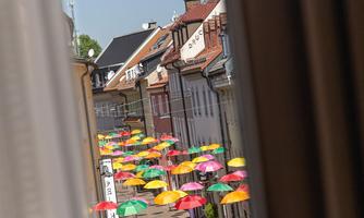 A picturesque street view with colorful umbrellas decorating the street. The historic buildings give the scene a charming character.