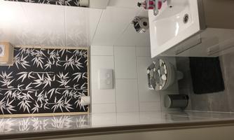 A modern bathroom with elegant furnishings. The walls are decorated with a stylish bamboo pattern.