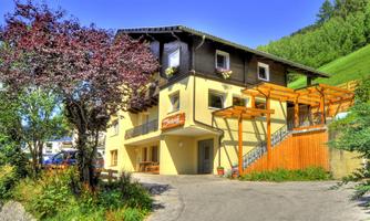 A charming house with a garden and a terrace.  
Surrounded by green hills and trees.