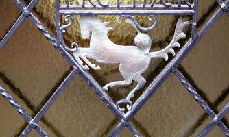 An artistic metal plaque featuring a stylized horse motif. The inscription "PRETTNER" is visible above it.