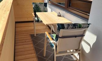 Cozy balcony with a table and chairs.