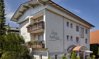 A modern building with the inscription "Haus Astig" in the foreground. There are balconies with plants and a pleasant environment.