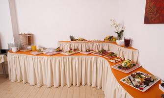 A buffet with various dishes on a decorated table. There are fresh fruits, salads, and desserts in an appealing presentation.