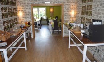 A bright and inviting café with wooden floors and stone veneer walls. Various drinks and snacks are available on the tables.