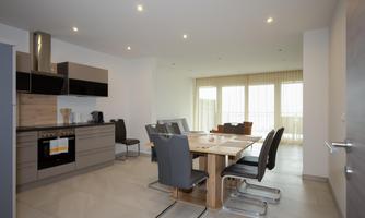 Modern kitchen with dining area. Bright rooms and large windows create a friendly atmosphere.