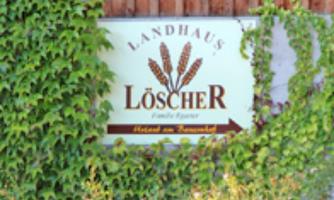 A sign of the country house LöschER, surrounded by ivy and a wooden-paneled wall. It showcases the hospitality of the Epprecht family.