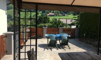 A cozy terrace with two chairs and a view of green hills. The surroundings are quiet and inviting.