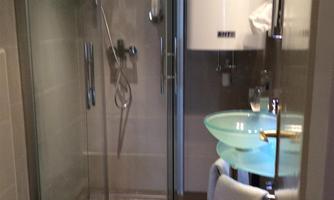 A modern bathroom with a shower, sink, and toilet. The decor is stylish and functional.