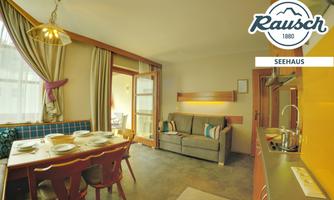 A cozy vacation apartment with a dining area and a sofa. A large window area provides plenty of light and an inviting atmosphere.