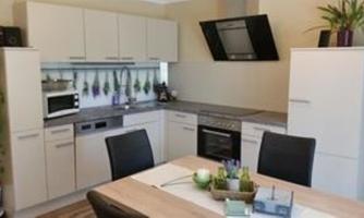 A modern kitchen with elegant, bright cabinets and modern appliances. Plants and decorative elements are on the table.