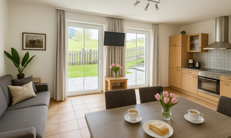 A bright living room with a dining table, two cups of coffee, and a bouquet of tulips. Large windows provide a view of the outdoor area with lawn and fence.
