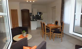 A bright and modern apartment with an open kitchen and a dining area. The living space is cozy and invitingly designed.
