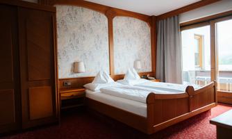A stylish bedroom with a double bed and two nightstands. The room has large windows that offer a view outside.