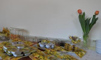 A table with various foods in colorful packages and jars. On the right side, there are fresh tulips in a vase.