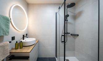 A modern bathroom with a large shower and a sink. The lighting design and neutral colors create an inviting atmosphere.