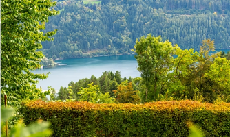 Two comfortable sun loungers await in the green grass, before you the Millstätter See and the surrounding mountains. Here you can put your feet up, enjoy the peace, and watch the children playing in the garden.