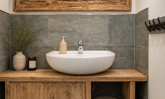 A modern bathroom with a sink on a wooden shelf. The room features natural materials and a stylish atmosphere.