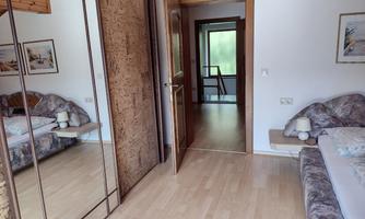 An inviting room with a bed and a large mirror. The floor is light, and the room feels friendly and spacious.