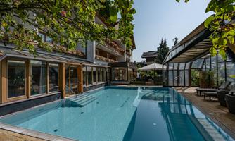 A beautiful pool area with clear water and a modern ambiance. Surrounding plants and sun umbrellas create a relaxed atmosphere.