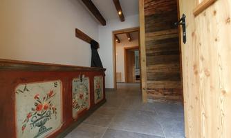 An inviting hallway with rustic wood and decorative walls. The room is designed to be bright and friendly.