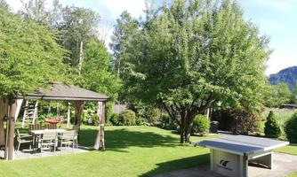 A beautiful garden with a gazebo and a table tennis table. Surrounded by trees and green spaces, it invites you to relax.