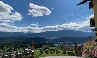 A beautiful view of the mountains and a lake. The sky is blue with some clouds, and the landscape is green and inviting.