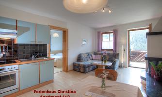 Modern kitchenette with dining area in a cozy apartment. Bright room with a sofa and access to the balcony.