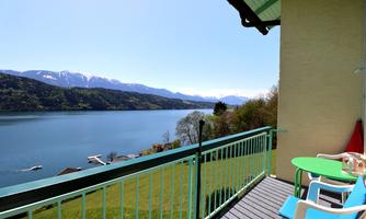 A beautiful view from the balcony of the lake and the surrounding mountains. The sky is clear and the landscape is tranquil and picturesque.