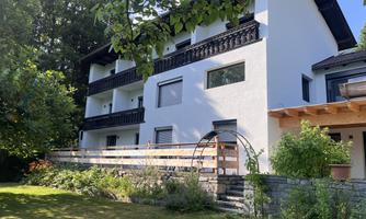 A modern building with several balconies in a green environment. The garden is well-maintained and provides an inviting atmosphere.