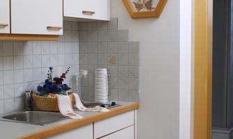 A bright and modern kitchen with white cabinets and a wood countertop. The space has a calm atmosphere, complemented by decorative elements such as a mural.