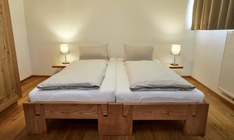 A cozy bedroom with a double bed and two nightstands. Soft lighting creates a relaxed atmosphere.