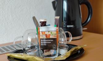 A tray with glasses, a selection of tea, and a kettle. It prepares a cozy tea time.