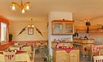An inviting restaurant with light wooden furniture and yellow tablecloths. The warm colors create a cozy atmosphere.