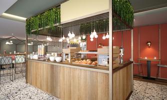 A modern café bar with a wooden counter and fresh baked goods. The atmosphere is friendly and inviting, with plants and warm lighting.