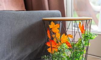 Small side table with autumn decor next to the sofa. Such details make the family nest cozy, almost like in your own living room.