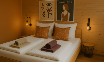 A modern bedroom with a cozy double bed. The walls are painted in warm tones, decorated with stylish posters.