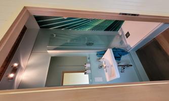 A modern bathroom with a shower and a sink. The walls are painted in soft colors and there are decorative elements.