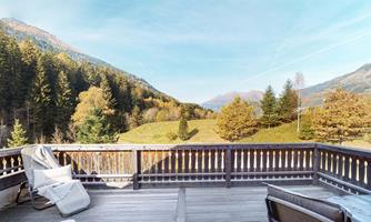 A cozy balcony with a view of a picturesque mountain landscape. The autumn forests and gentle hills create a relaxing atmosphere.