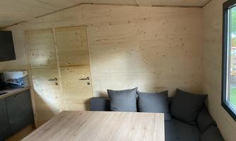 A cozy room with wood paneling and modern furniture. A table and a couch invite you to relax.