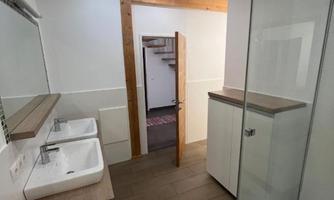 A modern bathroom with two sinks and a shower cubicle. The rooms are bright and simply designed.