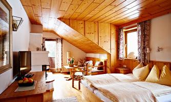 A cozy bedroom with wood paneling and two beds. The room is bright and has large windows that allow plenty of light in.