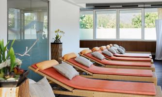 A relaxing area with loungers and large windows that let in plenty of light. The loungers are equipped with comfortable cushions, creating a peaceful atmosphere.