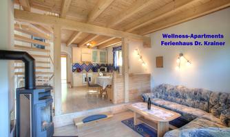 A bright living room with a cozy couch and an open kitchen. The room has wooden beams and hardwood floors, creating a warm atmosphere.