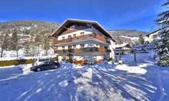 A modern building in a snowy landscape. Surrounded by mountains and trees, the scene radiates tranquility and winter enchantment.
