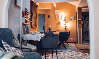 A cozy living space with a round entrance and bright walls. The area is well-lit and furnished in a style that creates an inviting atmosphere.