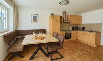 A modern kitchen with a dining area and bright furniture. The table is lovingly set and invites you to linger.