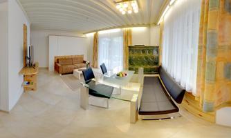 A modern living room with a glass table and black chairs. The large window front ensures plenty of daylight.