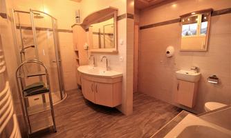 A modern bathroom with a shower, a sink, and a large mirror. The decor is bright and inviting, with appealing flooring.