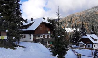 A cozy chalet in the snowy mountains. Surrounded by tall fir trees and a picturesque mountain landscape.
