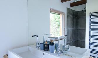 In the bathroom there is a double sink as well as a towel radiator and a walk-in shower.